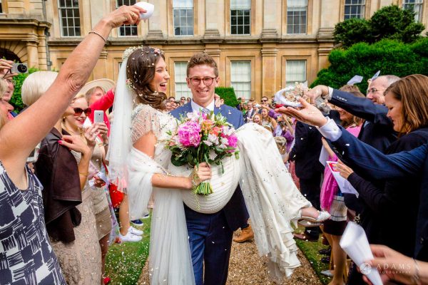 Cambridge Wedding Photographer groom curries the bride on his hands