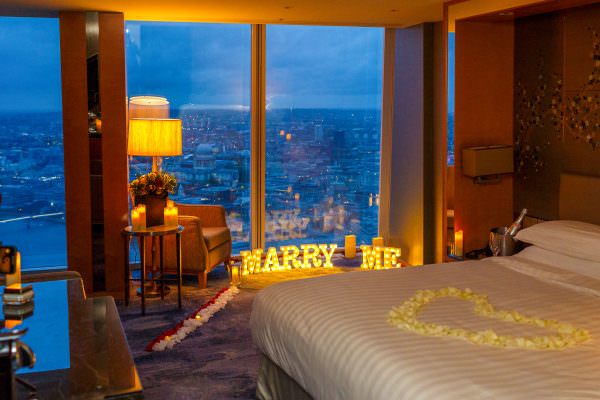 A glowing light-up "Marry Me" sign beautifully set up for a luxury marriage proposal inside The Shard, overlooking the London skyline.