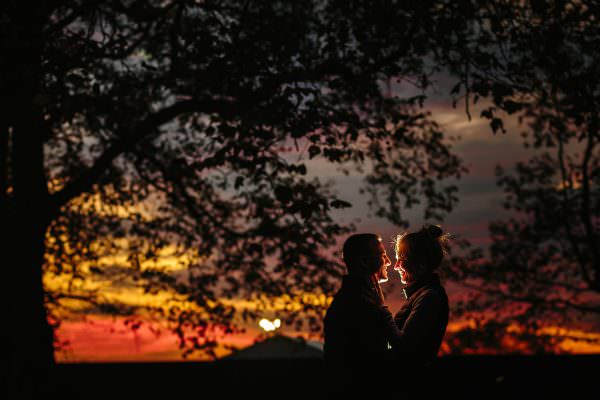 Stunning golden hour sunlight glowing behind a happy couple celebrating their marriage proposal in Hyde Park.