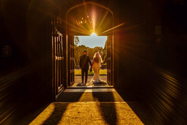 Married couple in doorway at their venue in London with the sunset view